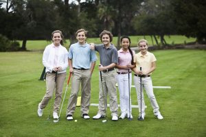 Juniors on the golf driving range, taking golf clinic.