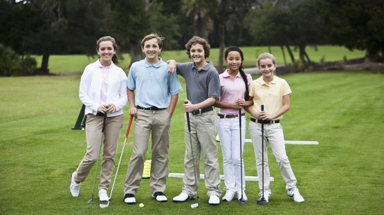 Juniors on the golf driving range, taking golf clinic.