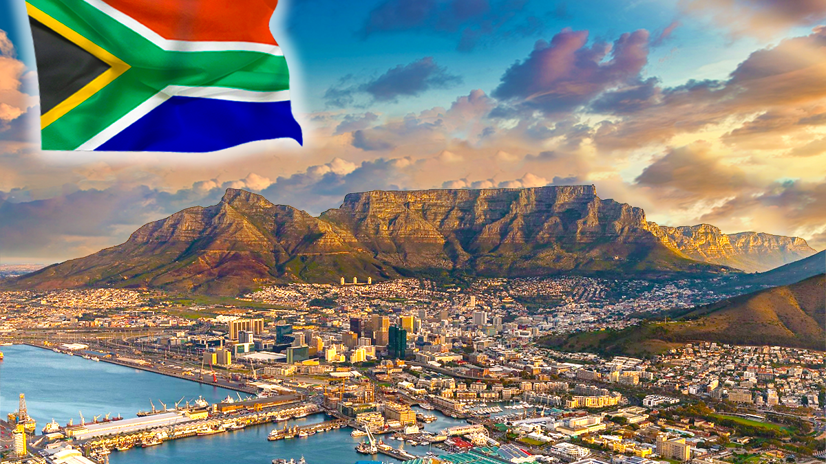 South African flag waving in left corner of beautiful golden hour with blue sky of South Africa Mountains, sea, and community