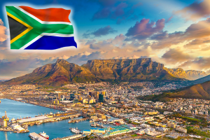 South African flag waving in left corner of beautiful golden hour with blue sky of South Africa Mountains, sea, and community